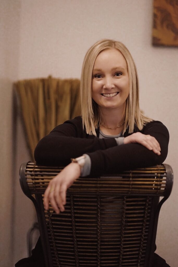 A woman sitting in a chair with her arms crossed.